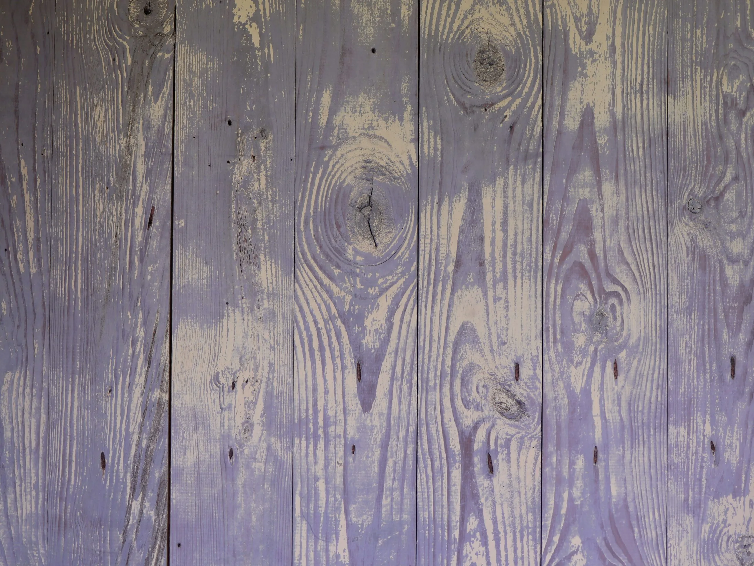 a close up of a wooden wall with purple paint
